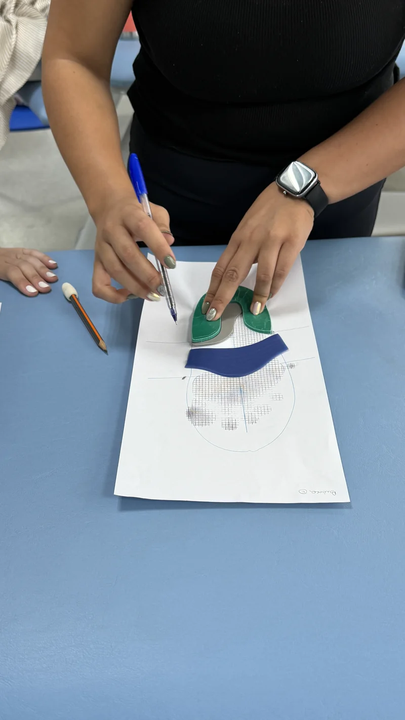 Mãos posicionando elementos sobre uma palmilha durante a prática