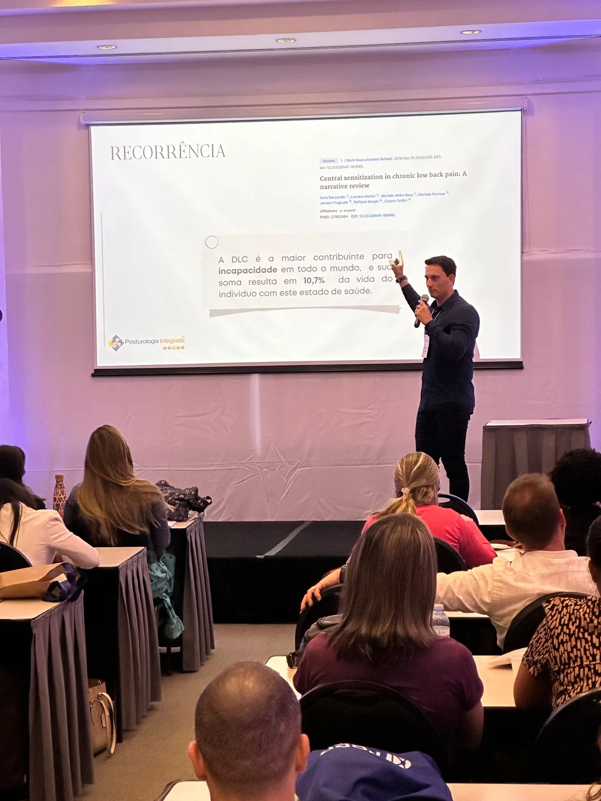 Palestra sobre recorrência e dor lombar crônica com referência científica